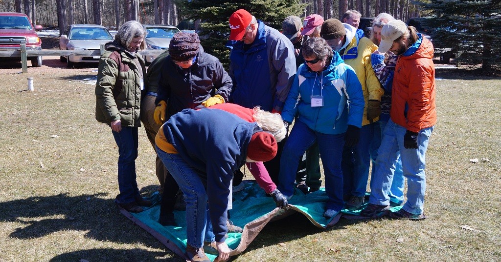 A group of participants at the Crew Leader Retreat work through a team-building exercise.