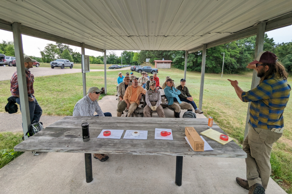 An Alliance staff members talks to a group of volunteers about safety protocols for Swampers.