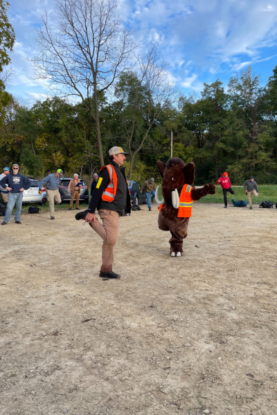 An Alliance staff member and the Monty the Mammoth Mascot help leads stretches.