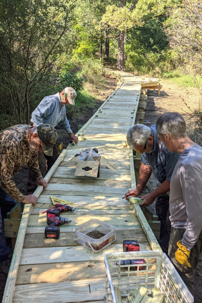 Volunteers carefully measuring out pieces for the edge of the boardwalk. Photo by Dave Caliebe.